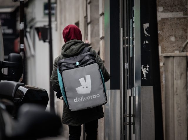 A man working for the food delivery company Deliveroo looks for his delivery address in an empty street in Paris on March 18, 2020, after a strict lockdown came into effect in France to stop the spread of COVID-19 (novel coronavirus). - A strict lockdown requiring most people in France …