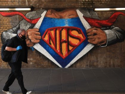 LONDON, ENGLAND - MAY 29: A man wearing a face mask and gloves walks past an NHS mural by street artist Lionel Stanhope on May 29, 2020 in the Waterloo East area of London, England. The British government continues to ease the coronavirus lockdown by announcing schools will open to …
