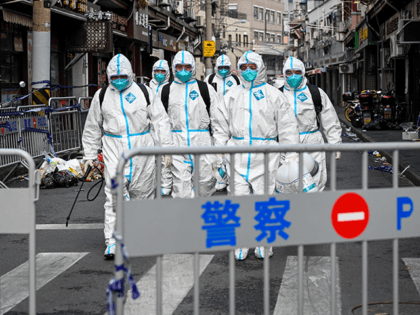 Health workers in protective gear walk out from a blocked off area after spraying disinfectant in Shanghai's Huangpu district on January 27, 2021, after residents were evacuated following the detection of a few cases of COVID-19 coronavirus in the neighbourhood. (Photo by STR / AFP) / China OUT (Photo by …