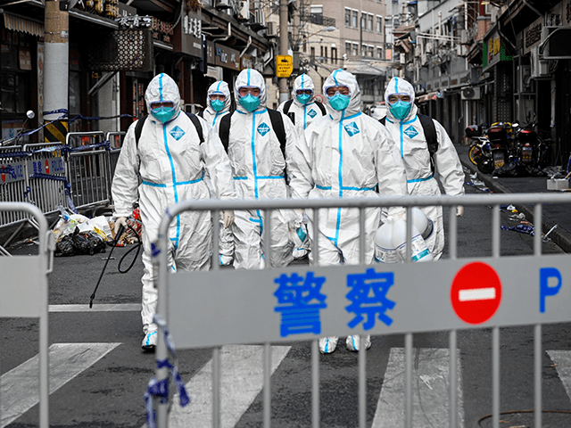 Health workers in protective gear walk out from a blocked off area after spraying disinfectant in Shanghai's Huangpu district on January 27, 2021, after residents were evacuated following the detection of a few cases of COVID-19 coronavirus in the neighbourhood. (Photo by STR / AFP) / China OUT (Photo by STR/AFP via Getty Images)