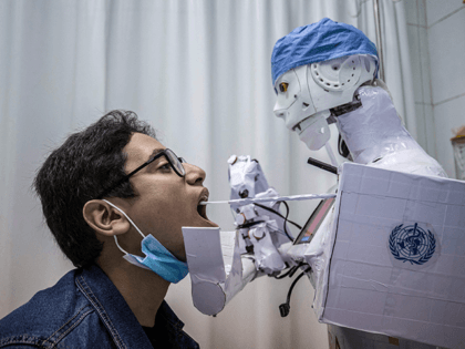 A prong extending from the CIRA-03 remote-controlled robot prototype approaches the mouth of a volunteer to extract a throat swab sample, as part of a self-funded project to assist physicians in running tests on suspected COVID-19 coronavirus patients in a bid to limit human exposure to disease-carriers, at a private …