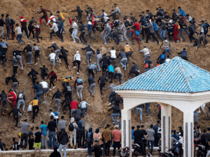 TOPSHOT - Migrants avoid the Moroccan police as they try to reach the border between Moroc