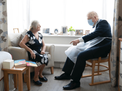 LONDON, ENGLAND - SEPTEMBER 07: Prime Minister Boris Johnson talks to resident Kathleen during a visit to Westport Care Home in Stepney Green, ahead of unveiling his long-awaited plan to fix the broken social care system on September 7, 2021 in London, England. (Photo by Paul Edwards / WPA Pool …