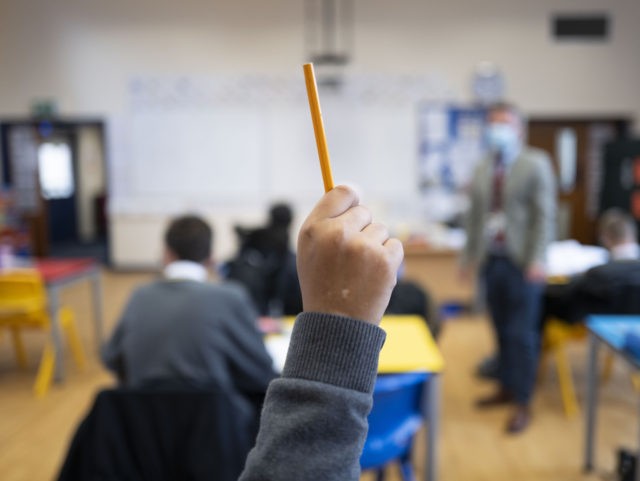 CARDIFF, WALES - SEPTEMBER 14: A pupil raises their hand during a lesson at Whitchurch High School on September 14, 2021 in Cardiff, Wales. All children aged 12 to 15 across the UK will be offered a dose of the Pfizer-BioNTech Covid-19 vaccine. Parental consent will be sought for the …