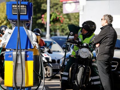 A motorist refills the fuel tank of their motorbike at a Jet petrol station in Leyton, east London on September 29, 2021. - British troops are expected to be deployed within days to help ease a fuel supply crisis, the government said on Wednesday, as the retail and hospitality sectors …