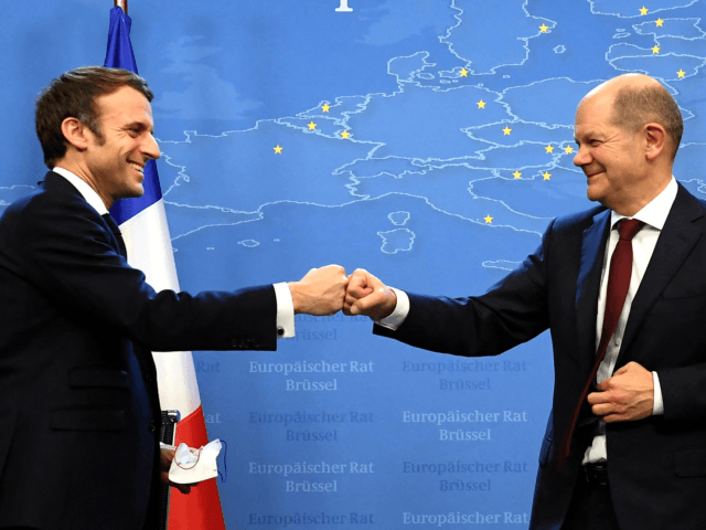 France's President Emmanuel Macron (L) and Germany's Chancellor Olaf Scholz bump fists after holding a joint press conference during an European Union (EU) summit at the European Council Building at the EU headquarters in Brussels on December 17, 2021. (Photo by JOHN THYS / POOL / AFP) (Photo by JOHN …