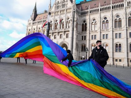 LMBTQ activists deploy a 30-meter-long rainbow-colored flag in front of the Hungarian Parliament building on January 21, 2022 prior to a press conference by Budapest Pride and European Pride Organizers Association (EPOA). - Organizers announced that this year's Budapest Pride Parade will be held in the capital on July 23. …
