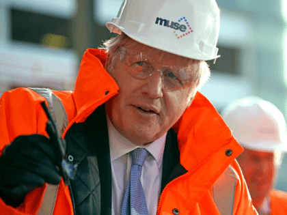 Britain's Prime Minister Boris Johnson, wearing safety glasses and a hard hat, reacts duri