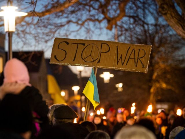 Protesters hold anti-war placards during a demonstration to protest against the Russian in