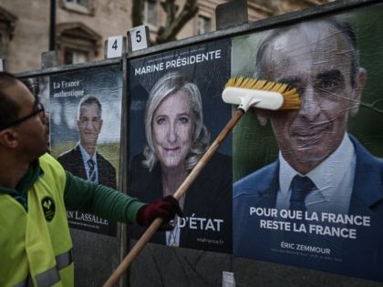 TOPSHOT - An employee of a display company placards presidential candidates' official campaign posters (From L) French agrarianist Resistons! party President and Member of Parliament Jean Lassalle and Marine Le Pen of the French far-right Rassemblement National (RN) party and French far-right Reconquete! party President Eric Zemmour on the first …