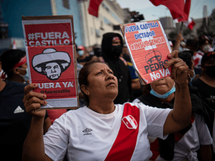 A woman holds signs during a protest against the governement of Peru's President Pedro Castillo, in Lima on April 05, 2022 - Peruvian President Pedro Castillo announced the end of a curfew in the capital Lima aimed at containing protests against rising fuel prices following crisis talks with Congress. (Photo …
