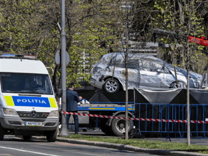 A vehicle that crashed into the entrance of the Russian Embassy to Romania in Bucharest on April 6, 2022 is lifted on a platform, after a man rammed his car into the gates of the diplomatic mission, then set himself on fire inside the vehicle and died, according to police. …