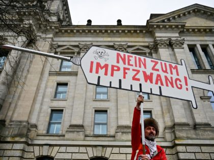 A vaccination opponent holds a paperboard syringe with the inscription "No to compulsory vaccination!" outside the Bundestag (lower house of parliament) on April 7, 2022 in Berlin, where delegates will debate on plans to impose compulsory Covid-19 vaccinations. (Photo by John MACDOUGALL / AFP) (Photo by JOHN MACDOUGALL/AFP via Getty …