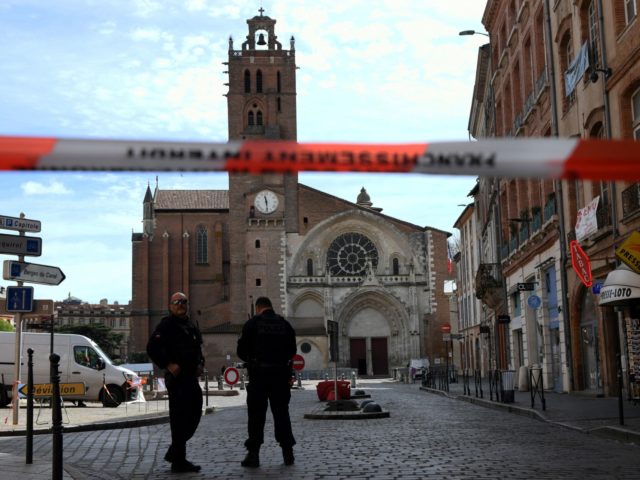 Security personnel gather at the entrance of Saint Etienne Cathedral in Toulouse, south-western France, on April 8, 2022, after the cathedral was evacuated following the discovery of a suspicious package. - The cathedral of Saint-Etienne in Toulouse was evacuated in the middle of mass after a man, who is still …