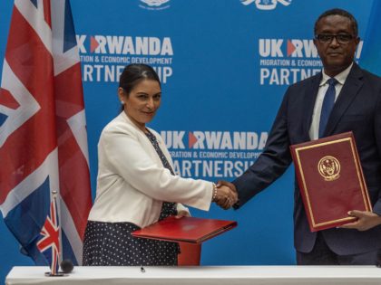 British Home Secretary Priti Patel (L), and Rwandan Minister of Foreign Affairs and International Cooperation Vincent Biruta, shake hands after signing an agreement at Kigali Convention Center, Kigali, Rwanda on April 14, 2022. - An agreement was finally announced Thursday with Rwanda, where British Home Secretary Priti Patel visited. Asylum …