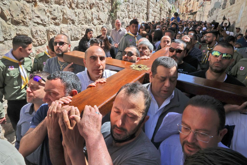 Christian worshipers carrying a wooden cross walk towards the Church of the Holy Sepulcher during the Good Friday procession in Jerusalem's Old City April 15, 2022. (Photo by HAZEM BADER/AFP) (Photo by HAZEM BADER/AFP via Getty Images)