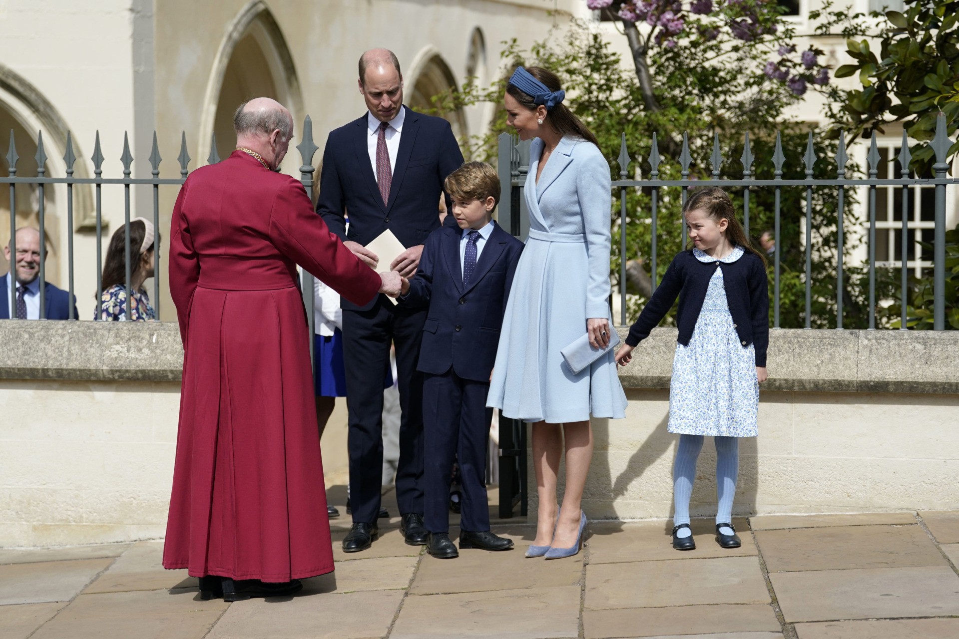 Britain's Prince George of Cambridge shakes hands with Dean of Windsor, The Right Revd David Conner (L) as he leaves with Britain's Prince William, Duke of Cambridge, Britain's Catherine, Duchess of Cambridge and Britain's Princess Charlotte of Cambridge (R) after attending the Easter Mattins Service at St. George's Chapel, Windsor Castle on April 17, 2022. (Photo by Andrew Matthews / POOL / AFP) 