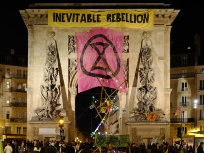 This photograph taken on April 17, 2022 shows Extinction Rebellion group's banners displayed on the Porte Saint Denis in central Paris. - Activists from the Extinction Rebellion group blocked a major road in central Paris disrupting traffic to protest "inaction" on climate change from world leaders. (Photo by Ludovic MARIN …