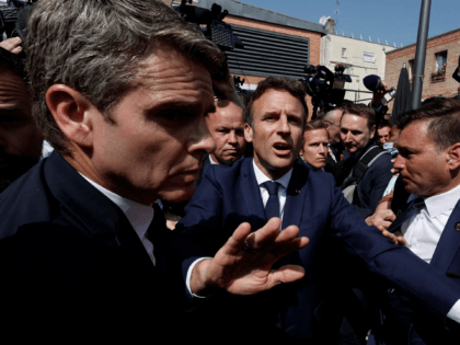 French President Emmanuel Macron (C) gestures as he meets residents at the Saint-Christophe market square in Cergy, Paris suburb, on April 27, 2022, during his first trip after being re-elected president. - Emmanuel Macron visits a working-class district of Cergy (Val d'Oise) on April 27, 2022 to meet residents, shopkeepers …