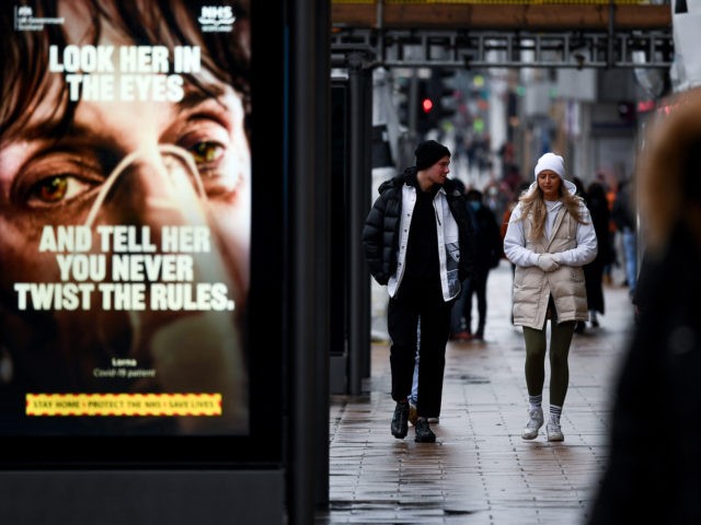 EDINBURGH - JANUARY 26: Members of the public walk past a government poster reminding peop