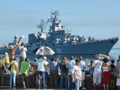 Cubans wave as the "Moskva" Russian guide missile cruiser arrives at Havana's harbour, on August 3, 2013. The vessel is part of a three-ship group in official visit to Cuba. AFP PHOTO/Adalberto ROQUE (Photo credit should read ADALBERTO ROQUE/AFP via Getty Images)