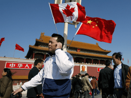 BEIJING, CHINA: A man walks past flags of Canada and China in front of Tiananmen Gate in Beijing, 21 October 2003, hoisted ahead of a four-day official visit by Canadian Prime Minister Jean Chretien. Members of Canada's parliament urged the Prime Minister to press Chinese authorities to improve their human …