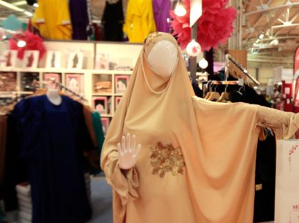 A Muslim woman passes next to a mannequin wearing a chador at the clothing stand in the commercial area of the 31st annual meeting of the Muslims of France organised by the Union of Islamic Organisations of France (UOIF), at the exhibition centre of Le Bourget, near Paris, on April …