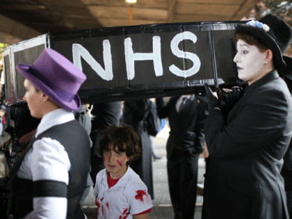 MANCHESTER, ENGLAND - OCTOBER 04: People carry a mock-up of a coffin with the letters 'NHS' on the side as they take part in an anti-austerity protest during the first day of the Conservative Party Autumn Conference 2015 on October 4, 2015 in Manchester, England. Conservative Party members are in …