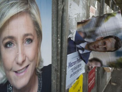 A picture taken on April 24, 2017 in Henin-Beaumont, northern France, shows campaign posters of French presidential election candidate for the far-right Front National (FN) party Marine Le Pen and candidate for the En Marche ! movement, Emmanuel Macron, one day after the first round of the Presidential election. Pro-European …