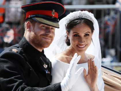 TOPSHOT - Britain's Prince Harry, Duke of Sussex and his wife Meghan, Duchess of Sussex wave from the Ascot Landau Carriage during their carriage procession on the Long Walk as they head back towards Windsor Castle in Windsor, on May 19, 2018 after their wedding ceremony. (Photo by Aaron Chown …