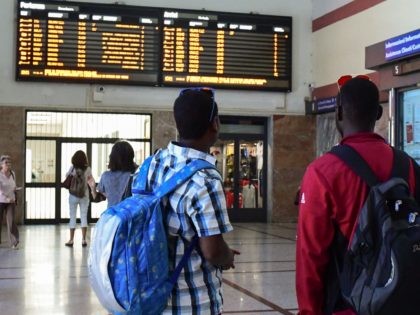 Migrants look at trains timetables at the Ventimiglia train station, northwestern Italy, on June 14, 2018. - An EU scheme to distribute migrants equitably around the bloc has failed miserably, with central European members flatly refusing the quotas and others, including France, falling far short of their allocated target. (Photo …