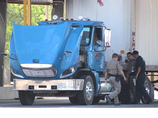 Texas DPS troopers inspect a commercial vehicle after it crossed through the Eagle Pass po