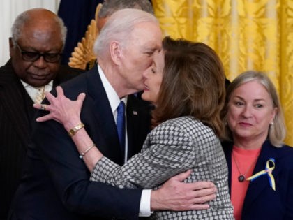 President Joe Biden kisses House Speaker Nancy Pelosi of Calif., during an Affordable Care Act event in the East Room of the White House in Washington, Tuesday, April 5, 2022. At left is House Majority Whip James Clyburn, D-S.C., and right is Rep. Susan Wild, D-Pa. Pelosi has tested positive …