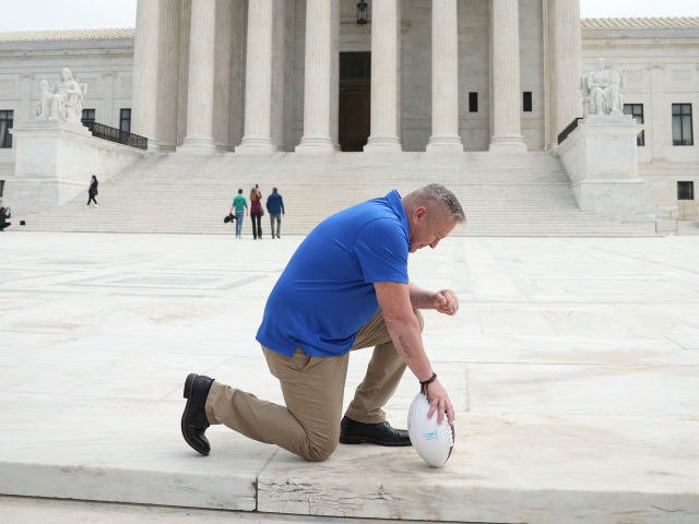 WASHINGTON, DC - APRIL 25: Former Bremerton High School assistant football coach Joe Kennedy takes a knee in front of the U.S. Supreme Court after his legal case, Kennedy vs. Bremerton School District, was argued before the court on April 25, 2022 in Washington, DC. Kennedy was terminated from his …