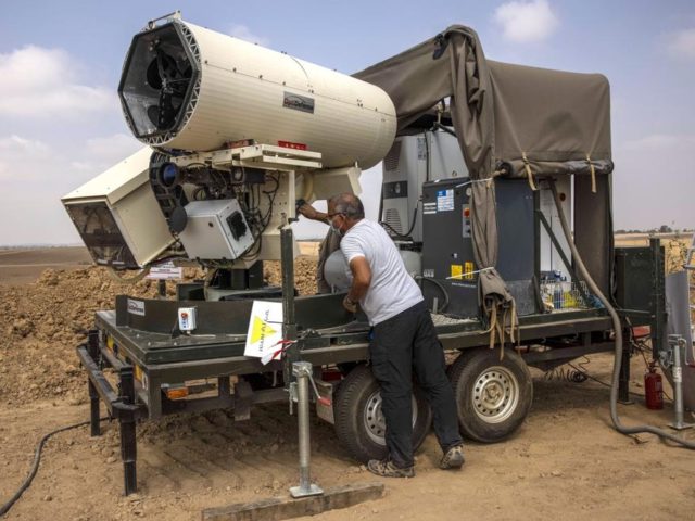 An Israeli police officer demonstrates a laser defense system designed to intercept explos