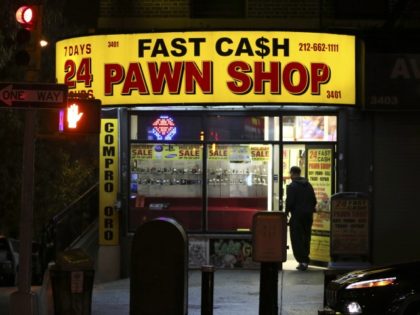 In this Dec. 1, 2016, photo, a man enters Fast Cash Pawn Shop early in the morning, in New York. In the middle of the New York night, customer services are available for everything from flower delivery and bedbug control to a pawn shop for cash-strapped desperadoes and housekeeping - …