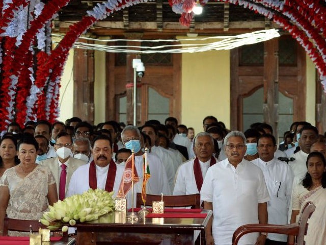 Sri Lanka's President Gotabaya Rajapakse (front 3R) and Prime Minister Mahinda Rajapakse (front 3L) along with new cabinet Ministers stand for the national anthem during the cabinet swearing-in ceremony at the Buddhist Temple of the Tooth in the ancient hill capital of Kandy, some 116 km from Colombo on August …