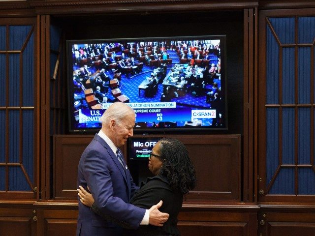TOPSHOT - US President Joe Biden embraces Judge Ketanji Brown Jackson as they watch the Se