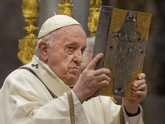 Pope Francis hoists the Gospel book during a Chrism Mass inside St. Peter's Basilica, at the Vatican, Thursday, April 14, 2022. During the mass the Pontiff blesses a token amount of oil that will be used to administer the sacraments for the year. (AP Photo/Gregorio Borgia)