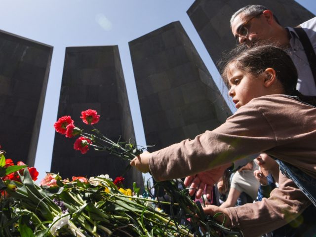 A young girl lays flowers at the Tsitsernakaberd Memorial in Yerevan on April 24, 2022 as