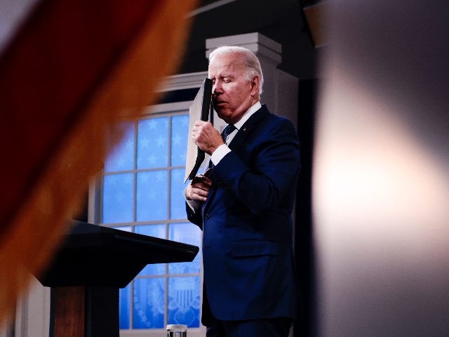 WASHINGTON, DC - DECEMBER 01: U.S. President Joe Biden covers his face as he coughs while