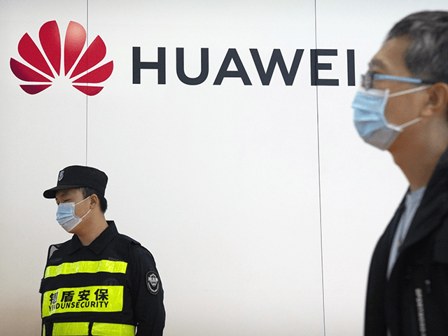 A security guard stands near a booth for Chinese technology firm Huawei at the PT Expo in