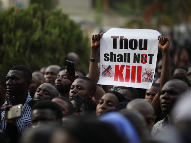 Christians faithfuls hold signs as they march on the streets of Abuja during a prayer and