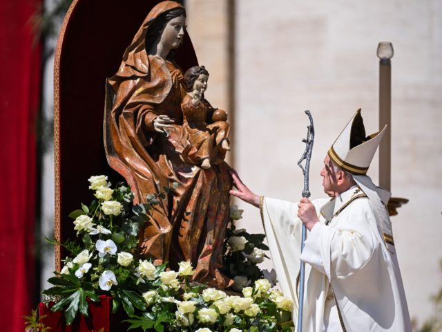 Pope Francis touches a sculpture of the Virgin Mary and the Christ Child at the end of the