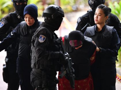 Indonesian national Siti Aisyah (C) is escorted by Malaysian police for her trial at the Shah Alam High Court, outside Kuala Lumpur on August 16, 2018 for her alleged role in the assassination of Kim Jong-Nam, the half-brother of North Korean leader Kim Jong-Un. - A Malaysian judge will on …