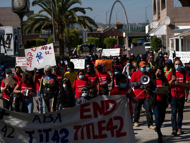 Migrants and asylum seekers march to protest against Title 42 policy heading to the Mexican side of the San Ysidro Crossing port in Tijuana, Baja California state, Mexico, on March 21, 2022. - Title 42 is a policy from Donald Trump's administration that stopped most arrivals at the southern border on the grounds that migrants could spread Covid-19. (Photo by Guillermo Arias / AFP) (Photo by GUILLERMO ARIAS/AFP via Getty Images)