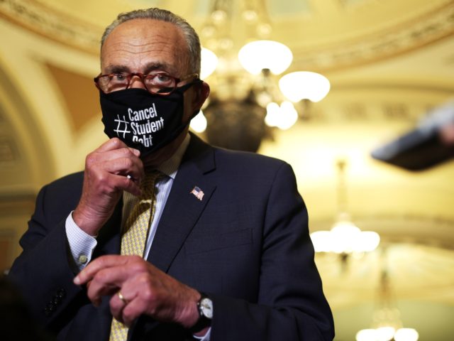 WASHINGTON, DC - JULY 27: U.S. Senate Majority Leader Sen. Chuck Schumer (D-NY) puts on a mask that reads "Cancel Student Debt" during a news briefing after a weekly Senate Democratic Policy Luncheon at the U.S. Capitol on July 27, 2021 in Washington, DC. Senate Democrats held a weekly policy …