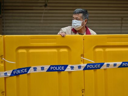 A man stands behind barriers during lockdown as a measure against the Covid-19 coronavirus in Jing'an district, in Shanghai on March 31, 2022. (Photo by Hector RETAMAL / AFP) (Photo by HECTOR RETAMAL/AFP via Getty Images)