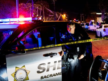 A Sacramento County Sheriff's Department officer looks on near the crime scene outside a c