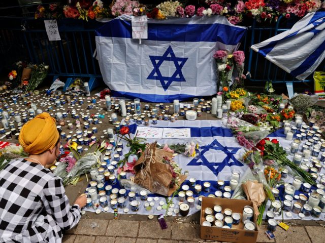 Israelis light candles at the site of a shooting attack the previous night at Dizengoff St